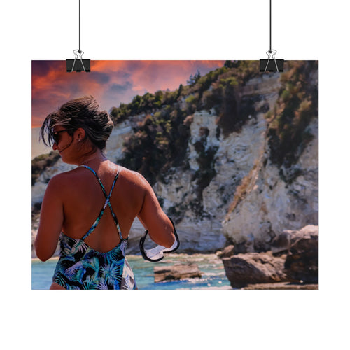 Person in a swimsuit overlooking a scenic coastal landscape with cliffs and water.