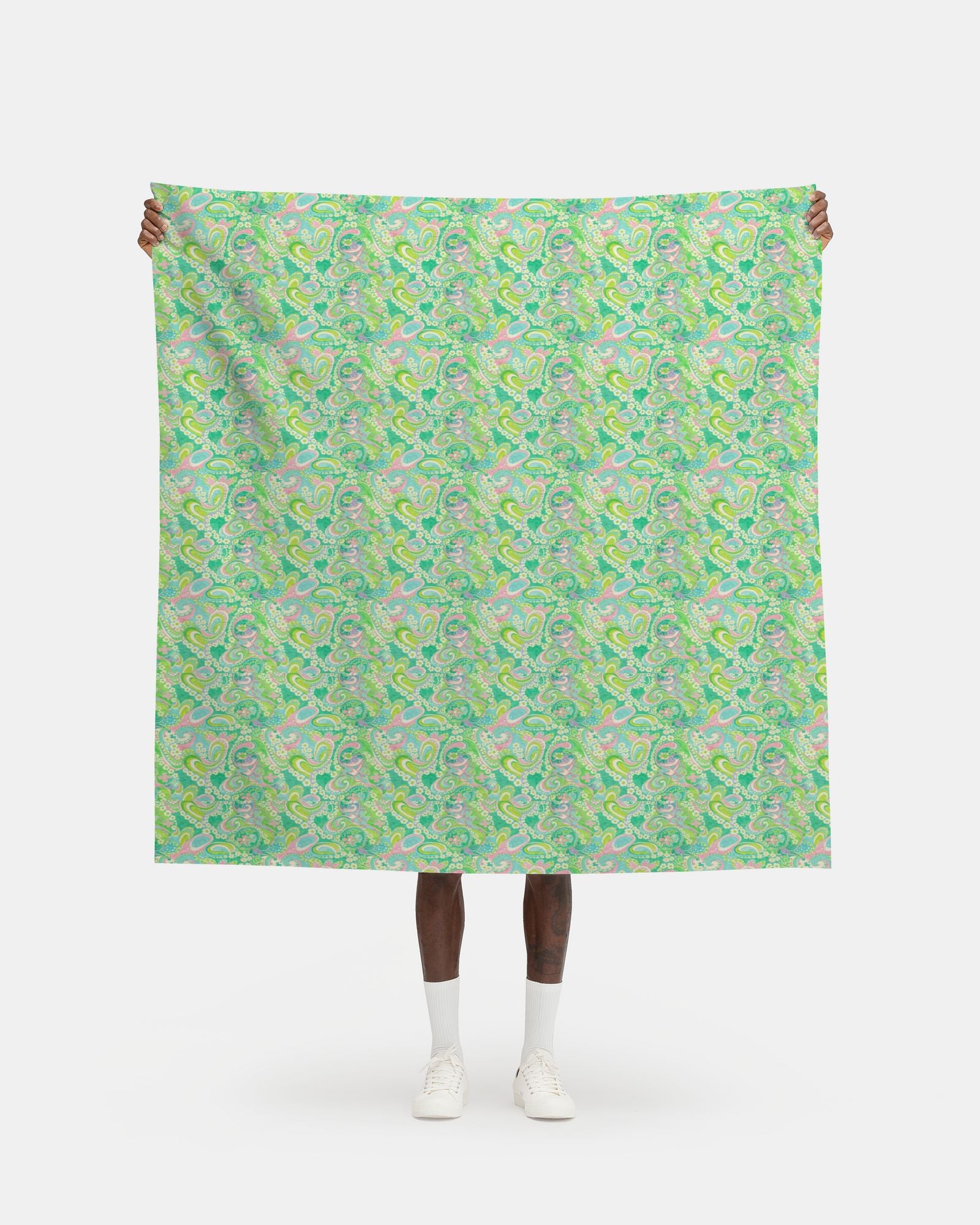 Person holding a large green patterned fabric against a white background